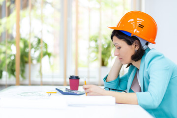 Photo of female engineer wearing orange helmet.