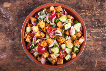 One of the options for Italian panzanella salad in a clay bowl, top view