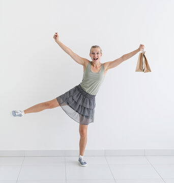 smiling woman dancing with eco friendly shopping bags and creadit card
