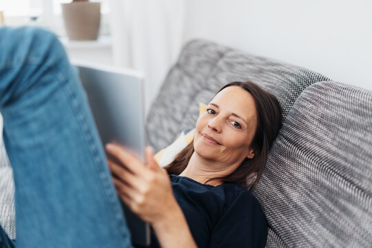 Middle-aged woman relaxing at home on a sofa