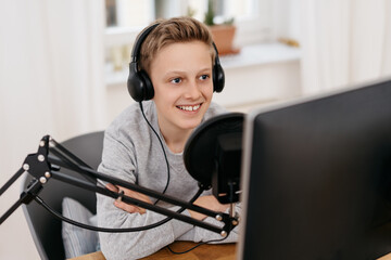 Happy friendly teenage boy recording a podcast
