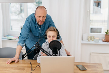 Father and son recording a podcast together