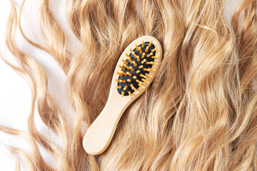 Blond female wavy hair and bamboo comb brush