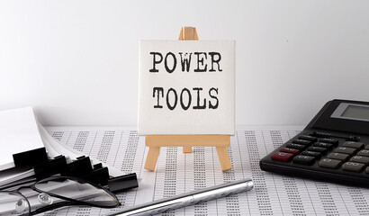 text POWER TOOLS on easel with office tools and paper.Top view. Business concept