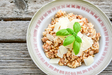 Italian  bolognese risotto with parmesan cheese on rustic background