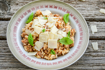 Italian  bolognese risotto with parmesan cheese on rustic background