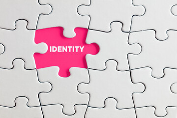 The word identity written on pink missing puzzle piece. Individuality, difference or diversity - obrazy, fototapety, plakaty
