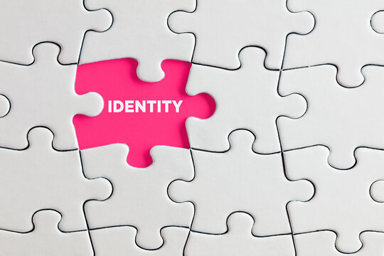 The word identity written on pink missing puzzle piece. Individuality, difference or diversity