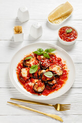 eggplant parmigiana on a white plate, top view