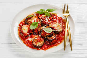 eggplant parmigiana on a white plate, top view