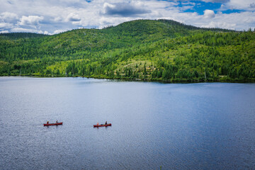 Fototapeta na wymiar People canoeing on lake Arthabaska in Parc National des Grands Jardins, a national park of Charlevoix, in Quebec province (Canada)