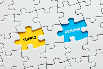 Missing puzzle pieces with the words supply and demand. Supply and demand relationship or balance