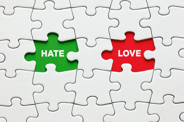 Fototapeta premium Missing puzzle pieces with the words hate and love. Relationship dilemma or confusion between to love or to hate