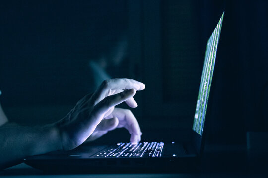 Closeup Shot Of A Male Working On His Computer In A Dark Room