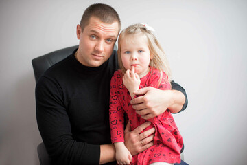 Emotional portrait of father and daughter on a gray studio background