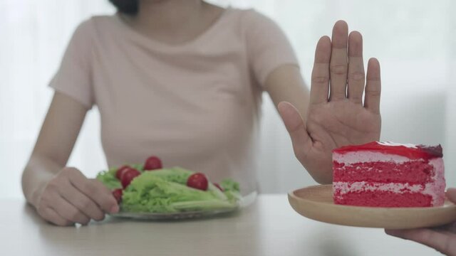 Women refuse to eat cake and choose to eat salad for diet. Healthy women and strong bodies. Cake have many of fat and sugar. diet and weight loss concept.