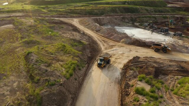Work dump truck. Mining truck transporting sand at sand quarry aerial view of mining machinery moving at sand mine top view of mining equipment at sand mine mining industry heavy vehicle at sandpit