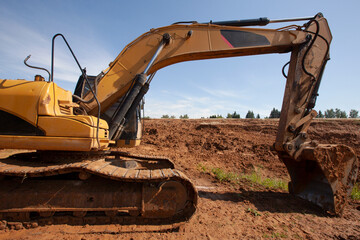 Crawler excavator at a construction site during digging ground . Backhoe on earthworks at construction site on blue sky background. Construction machinery for excavation