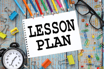 Lesson Plan. multicolored stationery on a blue wooden table. pencils lie on top. text in the...