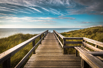 A wooden walking path in Wenningstedt on the german island of Sylt, North Sea - obrazy, fototapety, plakaty