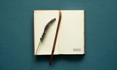 calendar 2022 with space for text, notebook, brown bookmark, lavender decoration, on a painted background, photo from above