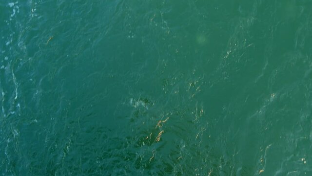 Ship's bow moving through blue water sea waves Overhead view from forecastle deck. Aerial view 4K Never endless turquoise ocean surface.