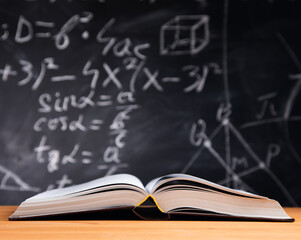 Open book on the table with blackboard background