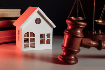 Sale of real property concept. Wooden model of house and judge gavel close-up
