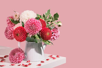 Autumn bouquet of beautiful dahlias flowers and petals on white table. Autumn festive decoration in pink colors, isometric view