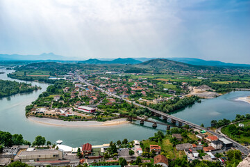 Fototapeta premium Amazing panorama of the Drin river and Bahcallek village - view from Rozafa Castle (Shkoder, Albania). Top view of the valley with the town and the old and new Ura e vjeter e Bahcallekut bridges