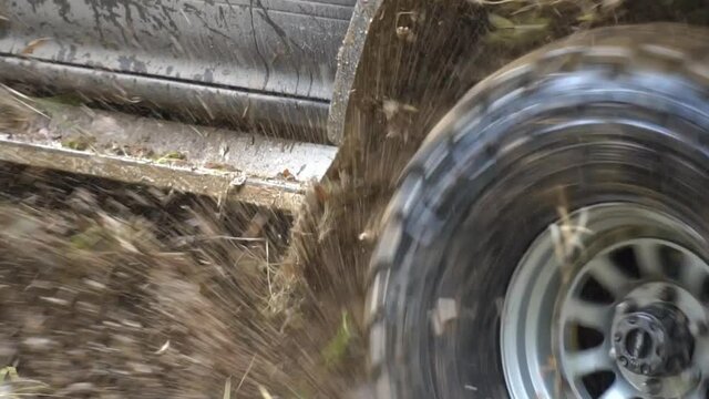 This stock video presents a close-up shot of a Jeep truck driving on an off-road track in slow motion. 