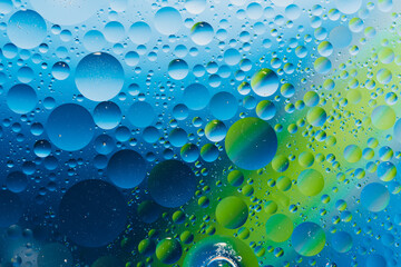 oil with bubbles on vibrant green and blue background. Abstract space background. Soft selective focus. macro of oil drops on transparent gel surface. copy space. air bubbles in water,