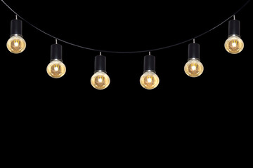 A row of light bulbs hanging from a wire on a black background.
