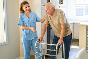 Freundliche Krankenpflegerin hilft Senior mit Rollator