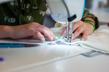 Sewing factory concept. Spools of thread and basic sewing tools including pins, needle, a thimble, and tape measure.