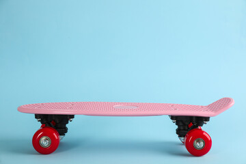 Pink skateboard on light blue background. Space for text