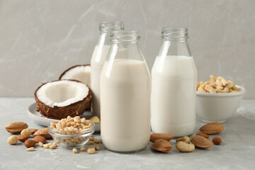 Different nut milks on light grey marble table