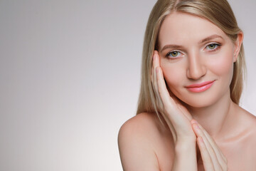 Fototapeta premium Portrait of young woman with beautiful face on beige background. Space for text
