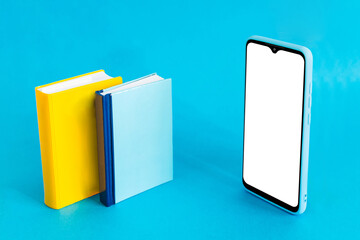 Isometric view of mobile phone and two books on light blue background. Distance education.