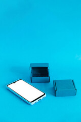 Isometric view of mobile phone and two boxes on light blue background. Shopping online..