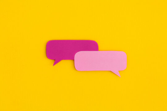 Paper speech bubbles on a yellow background. Top view with copy space. Flat lay.