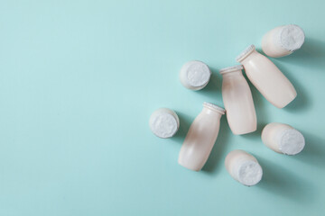 Bottles with probiotics and prebiotics dairy drink on light blue background.