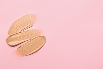 Sample of liquid skin foundation on pink background, top view. Space for text