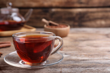 Freshly brewed rooibos tea on wooden table. Space for text