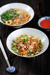 Mie Yamin or Yamin Noodle with Chopped Chicken Meat and Vegetable. Taste Sweet from Soy Sauce. Served on Ceramic Bowl with Sambal