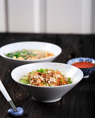 Mie Yamin or Yamin Noodle with Chopped Chicken Meat and Vegetable. Taste Sweet from Soy Sauce. Served on Ceramic Bowl with Sambal
