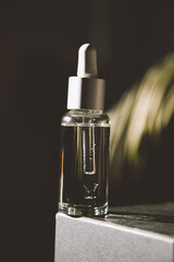 Naklejka premium Serum in a glass bottle with a pipette. Essential oil for the care of women's skin. Skin care, moisturizing cosmetic product.