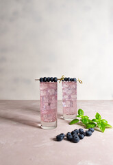 A glass with basil berry lemonade on the light background