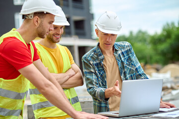 Three colleagues discussing a new building project outdoors