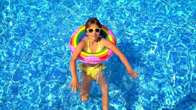 The child swims in a circle in the pool. Selective focus.